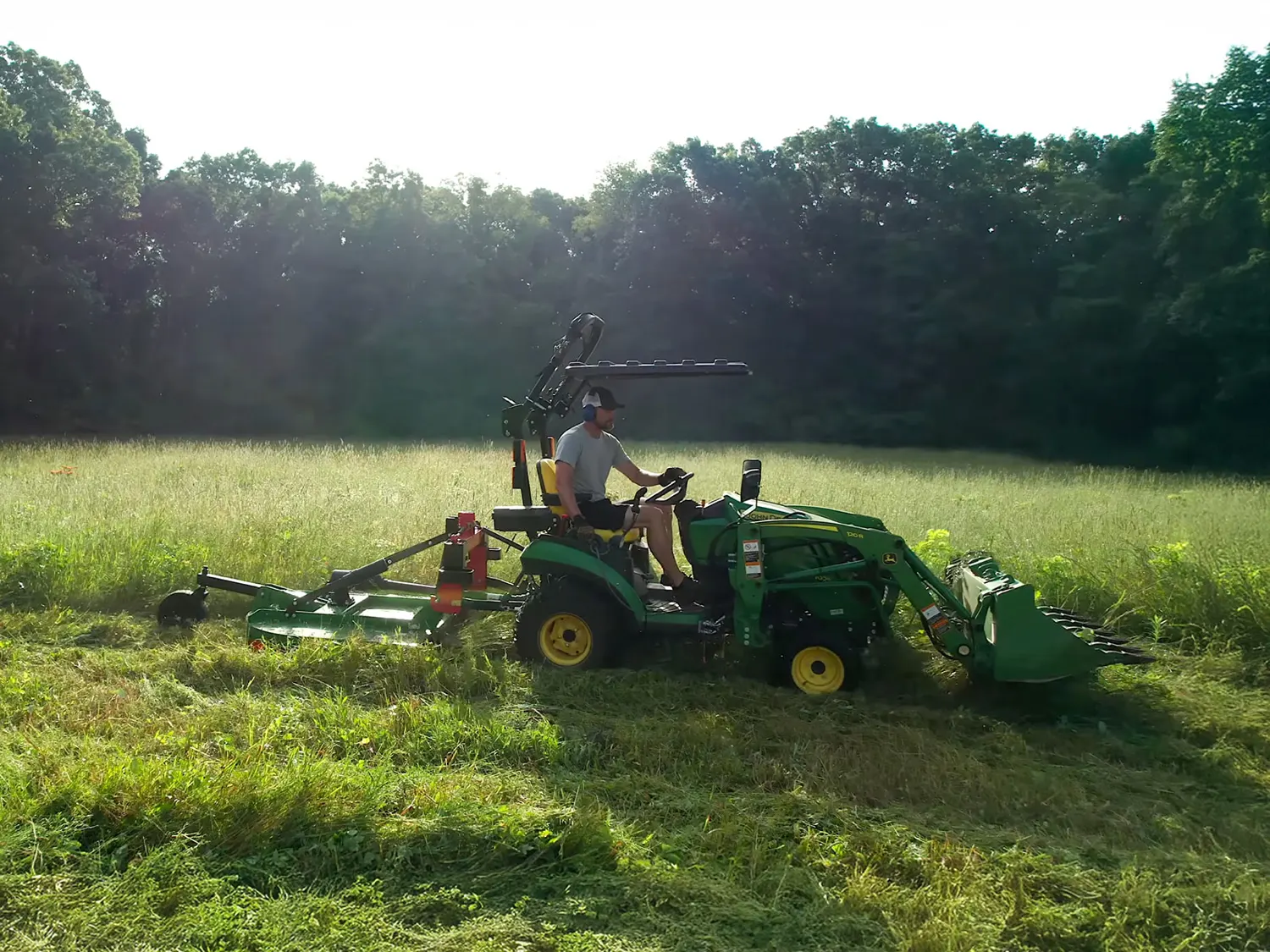 Tractor bush hogging an overgrown field in Northeast Louisiana