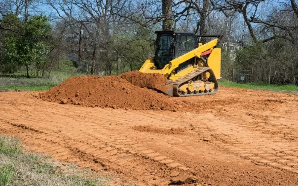 Equipment performing dirt work and grading on a rural Northeast Louisiana property