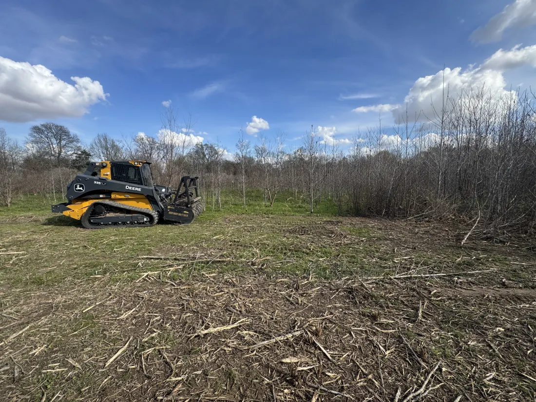 Compact track loader on a cleared Northeast Louisiana tract with the footprint stripped and ready for fill